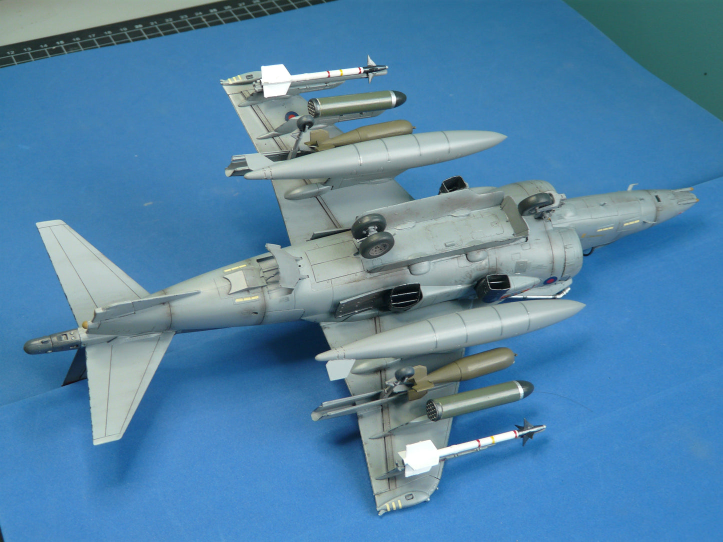 Model airplane with multiple missiles on a blue surface