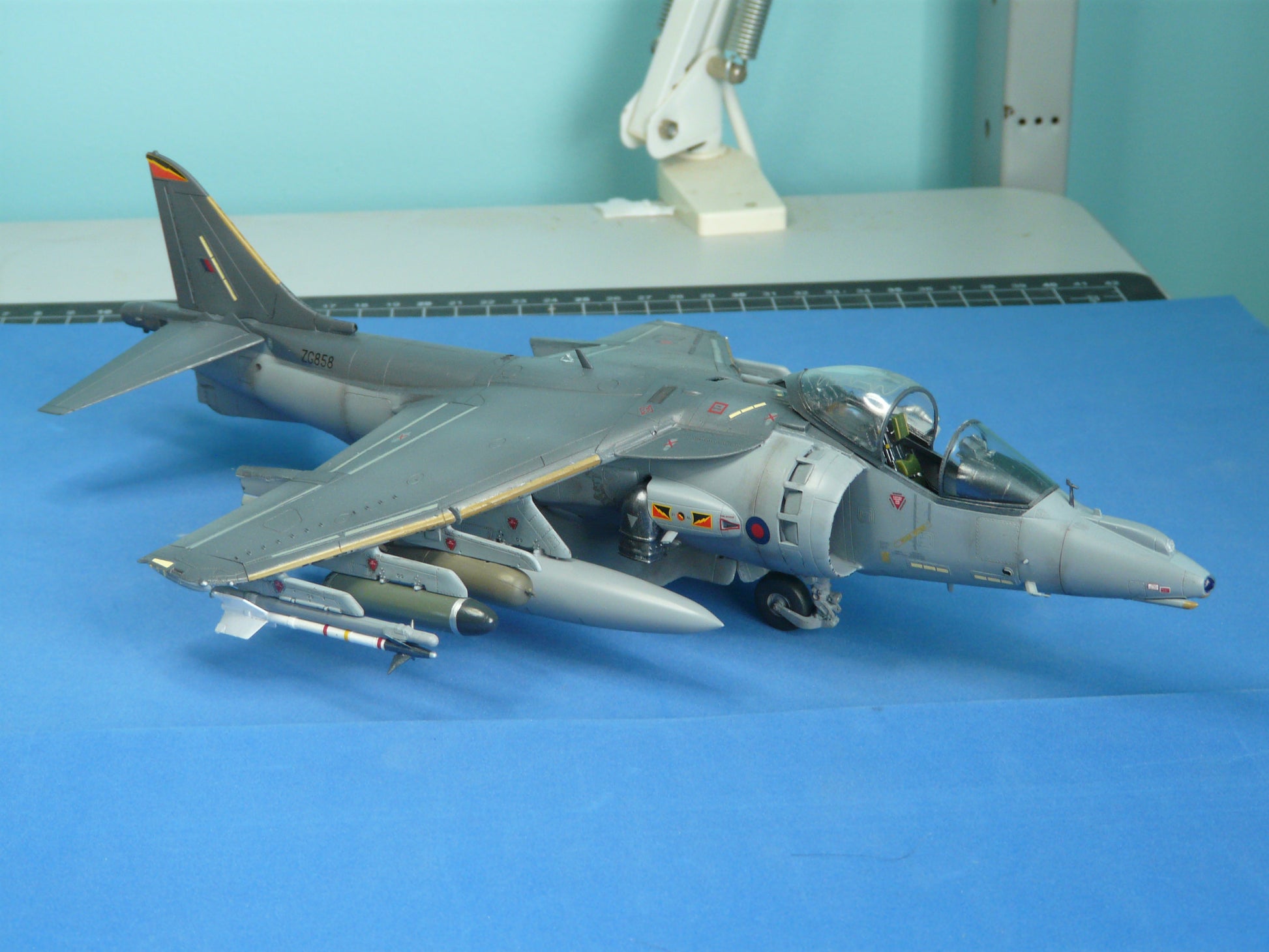 Model of a military aircraft on a blue surface with a light blue background