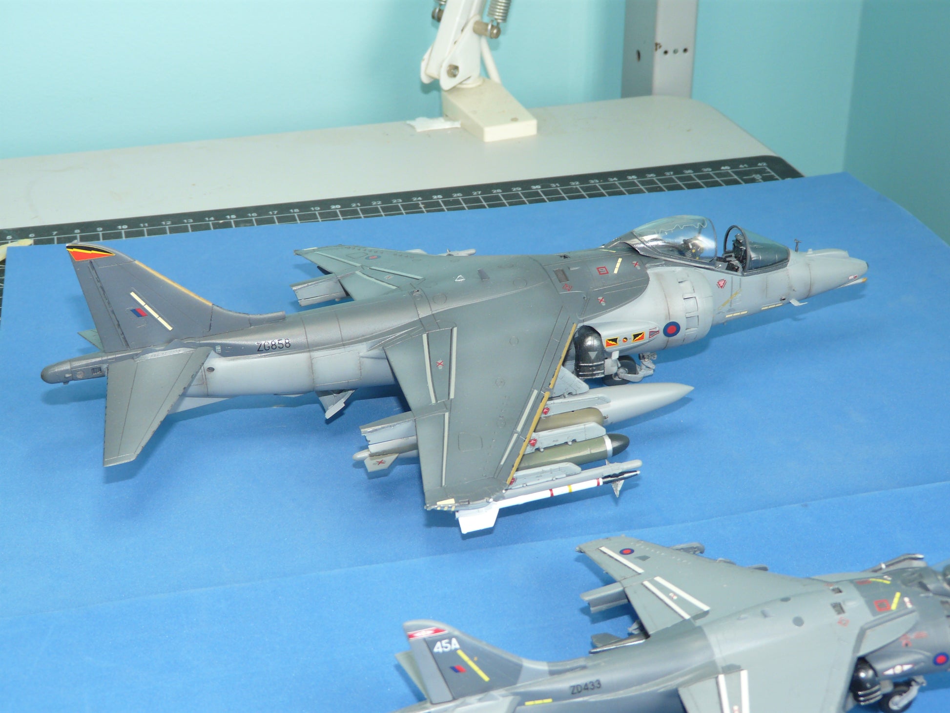 Model of a military aircraft on a blue surface with a light blue wall in the background